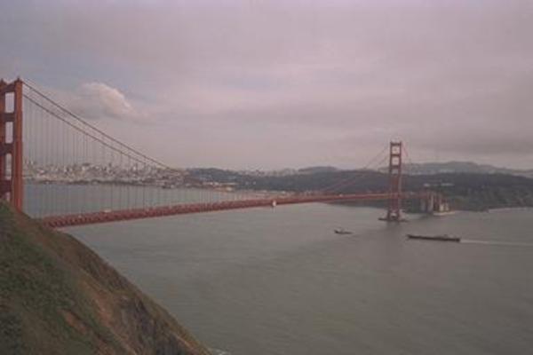 A boat going under the Golden Gate Bridge
