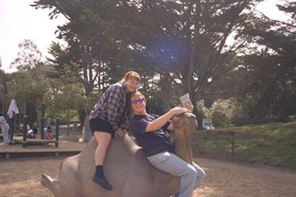 Xine and Ben riding a (plastic) camel