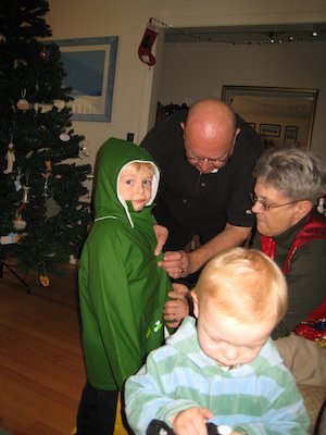 Tim trying on his raincoat with Nea, Poppy and Cole helping (12-24-2006 11:00)