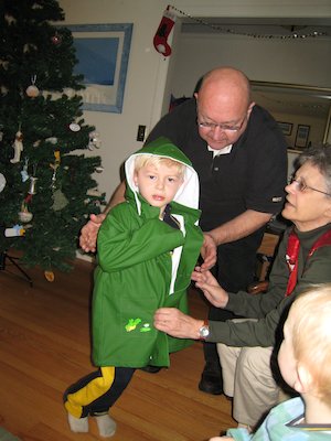 Tim trying on his raincoat with Nea, Poppy and Cole helping (12-24-2006 11:00)