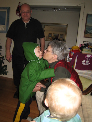 Tim trying on his raincoat with Nea, Poppy and Cole helping (12-24-2006 11:00)