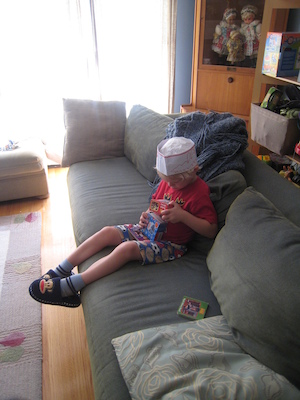 Cole, wearing a hat, reading (08-23-2009 13:08)