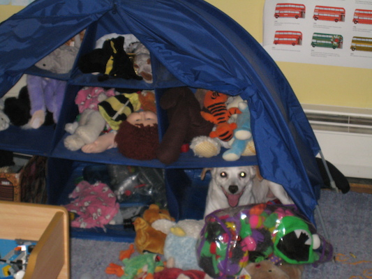 Emily hiding with the stuffed animals (06-23-2010 12:08)