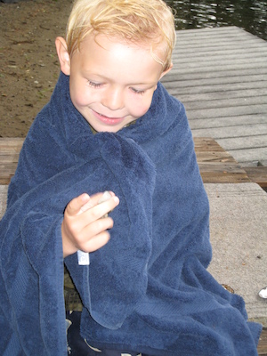 Cole wrapped up, examining a shell (07-14-2010 18:10)