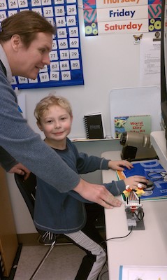 Tim showing Ben the Lego robot (02-17-2011 10:08)