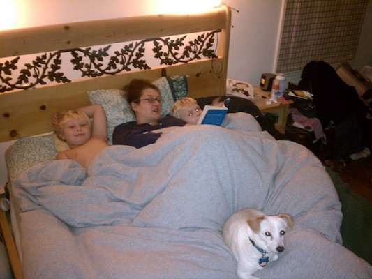 Tim, Xine, Cole and Emily reading in bed (10-21-2011 19:39)